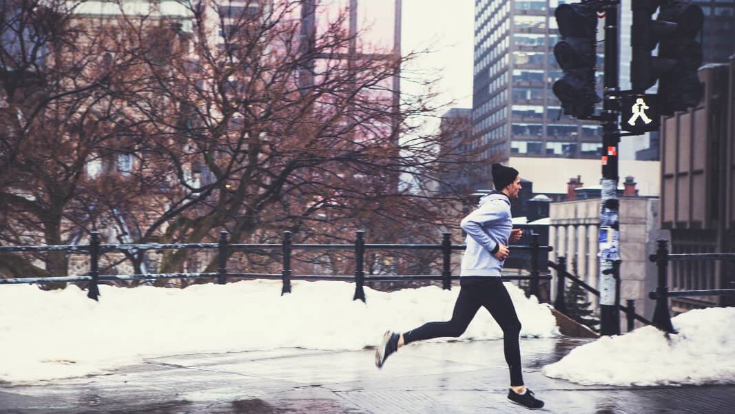 runner in the city with warm clothes by the snow