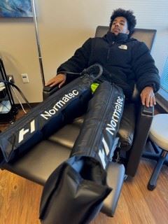 Image of a person using Normatec Compression Therapy apparatus