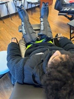 Image of a person using Normatec Compression Therapy apparatus from a top angle