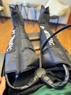 Image of a person using Normatec Compression Therapy apparatus from a first person view